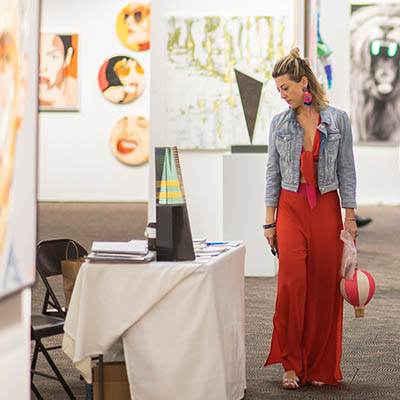 Woman walking looking at art at Art Palm Springs