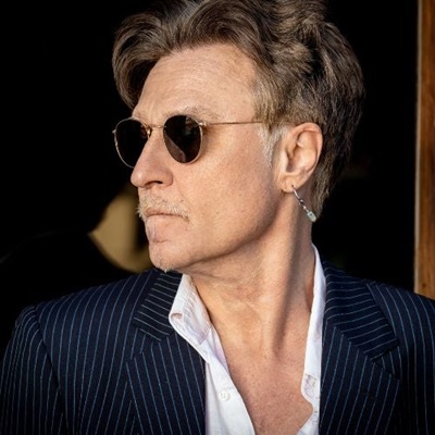 John Waite looking to the left wearing sunglasses