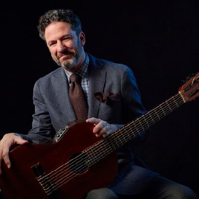 John Pizzarelli holding a guitar